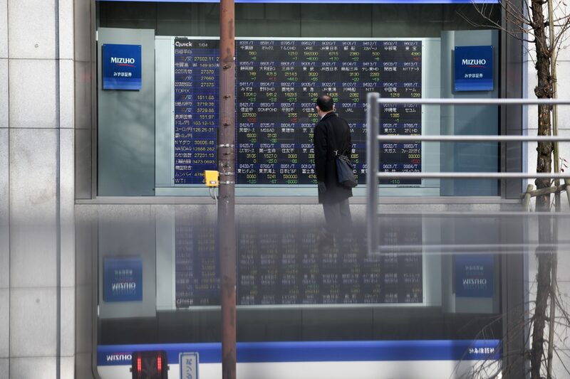 Un peatón mira un tablero de valores electrónicos fuera de una empresa de valores en Tokio, Japón, el lunes 4 de enero de 2021. Un peatón mira un tablero de valores electrónicos fuera de una empresa de valores en Tokio, Japón, el lunes 4 de enero de 2021.