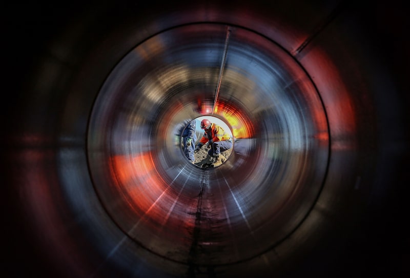 Un obrero inspecciona la construcción de un ducto de gas natural. Un obrero inspecciona la construcción de un ducto de gas natural.