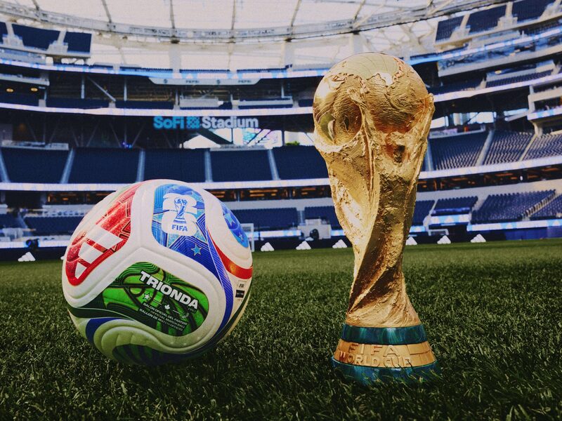 A bola oficial da Copa do Mundo de 2026, a Trionda, fabricada pela Adidas, ao lado do icônico troféu entregue à seleção nacional campeã da competição (Foto: Divulgação) A bola oficial da Copa do Mundo de 2026, a Trionda, fabricada pela Adidas, ao lado do icônico troféu entregue à seleção nacional campeã da competição (Foto: Divulgação)