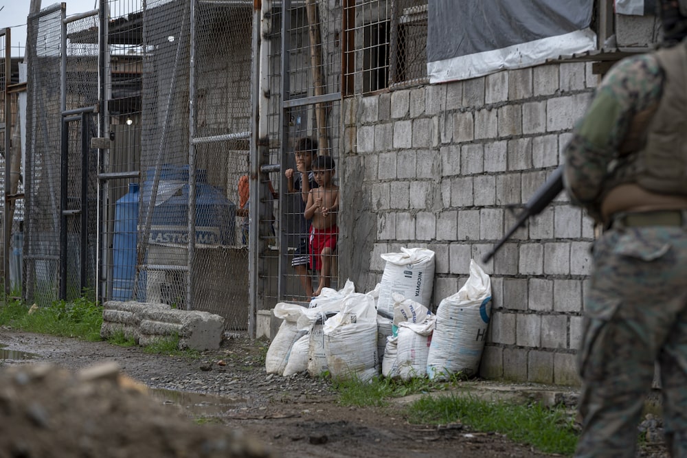 Los niños observan cómo militares y oficiales de policía llegan para realizar redadas en hogares en Durán, Ecuador, el 1 de febrero. Fotógrafo: Vicente Gaibor/Bloomberg Los niños observan cómo militares y oficiales de policía llegan para realizar redadas en hogares en Durán, Ecuador, el 1 de febrero. Fotógrafo: Vicente Gaibor/Bloomberg