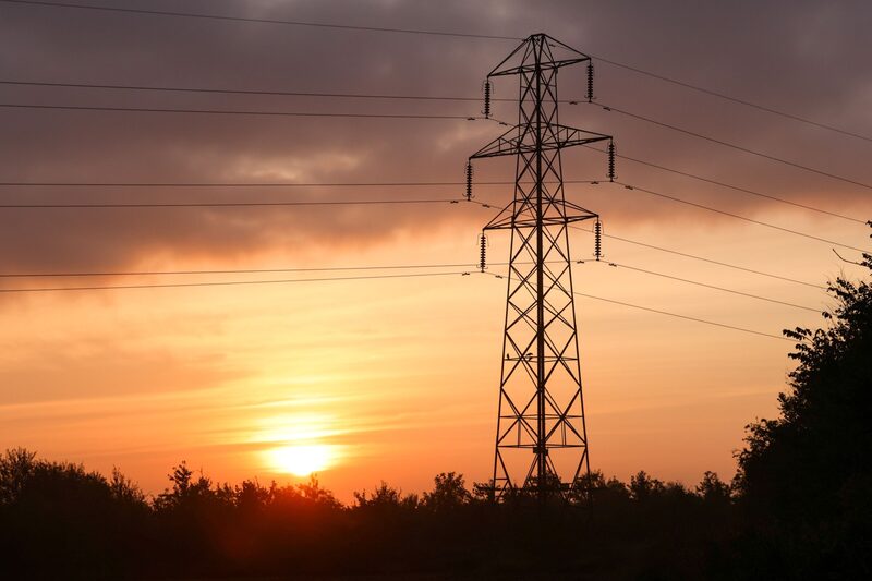El sol sale detrás de una torre de transmisión eléctrica. El sol sale detrás de una torre de transmisión eléctrica.