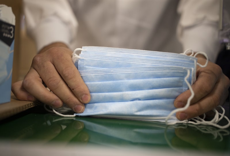 Una mujer apila cubrebocas protectores recién fabricados en Canadá. Una mujer apila cubrebocas protectores recién fabricados en Canadá.