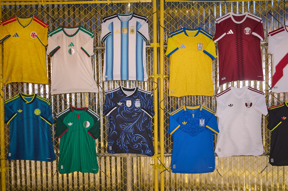 Team jerseys for Colombia, Tunisia, Argentina, Ukraine, and Qatar at a FIFA World Cup 2026 watch party hosted by Adidas at Brooklyn Bridge Park in the Brooklyn borough of New York, US, on Tuesday, June 16, 2026. The World Cup is back in the US for the first time since 1994 in its biggest version yet, encompassing 48 teams and 104 matches that are also being played in neighboring Canada and Mexico. Photographer: Bing Guan/Bloomberg Team jerseys for Colombia, Tunisia, Argentina, Ukraine, and Qatar at a FIFA World Cup 2026 watch party hosted by Adidas at Brooklyn Bridge Park in the Brooklyn borough of New York, US, on Tuesday, June 16, 2026. The World Cup is back in the US for the first time since 1994 in its biggest version yet, encompassing 48 teams and 104 matches that are also being played in neighboring Canada and Mexico. Photographer: Bing Guan/Bloomberg