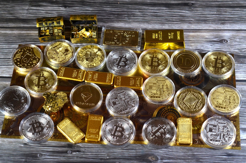 Bitcoin y lingotes de oro sobre billetes de dólares estadounidenses. Foto: Shutterstock. Bitcoin y lingotes de oro sobre billetes de dólares estadounidenses. Foto: Shutterstock.