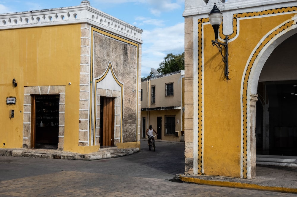 A resident rides a bicycle in the city center of Izamal, Yucatán, Mexico. A resident rides a bicycle in the city center of Izamal, Yucatán, Mexico.