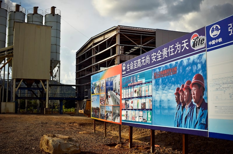 Carteles que representan a trabajadores chinos en la entrada a una fábrica ferroviaria del proyecto Tinaco-Anaco de China Railway Engineering Corporation en Guárico, Venezuela. Carteles que representan a trabajadores chinos en la entrada a una fábrica ferroviaria del proyecto Tinaco-Anaco de China Railway Engineering Corporation en Guárico, Venezuela.