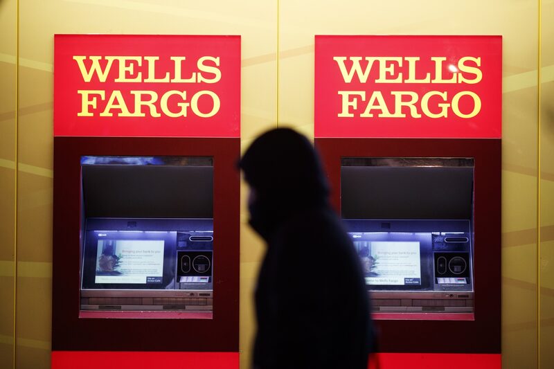 En la imagen, un peatón pasa junto a unos cajeros automáticos en una sucursal del banco Wells Fargo por la noche en Washington. En la imagen, un peatón pasa junto a unos cajeros automáticos en una sucursal del banco Wells Fargo por la noche en Washington.