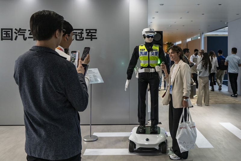 Visitantes observan y fotografían un robot con apariencia de agente de tránsito en una exhibición tecnológica en China. Visitantes observan y fotografían un robot con apariencia de agente de tránsito en una exhibición tecnológica en China.