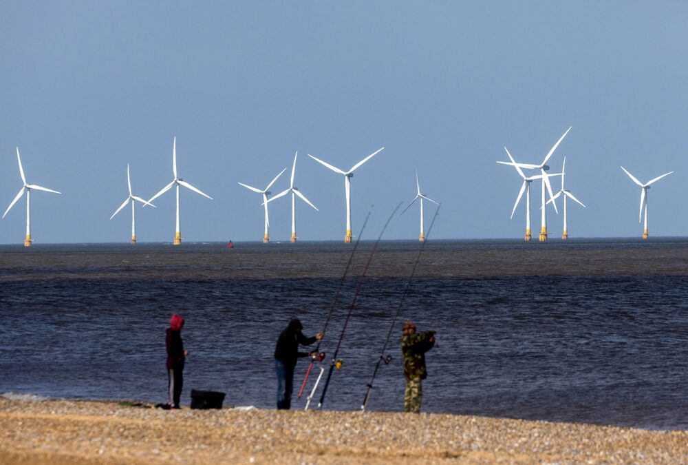 Offshore wind turbines beyond fishermen on the beach at the Scroby Sands Wind Farm, operated by E.ON SE, near Great Yarmouth, UK, on Friday, May 13, 2022. The U.K. will introduce new laws for energy to enable a fast build out of renewables and nuclear power stations as set out in the governments energy security strategy last month. Photographer: Chris Ratcliffe/Bloomberg Offshore wind turbines beyond fishermen on the beach at the Scroby Sands Wind Farm, operated by E.ON SE, near Great Yarmouth, UK, on Friday, May 13, 2022. The U.K. will introduce new laws for energy to enable a fast build out of renewables and nuclear power stations as set out in the governments energy security strategy last month. Photographer: Chris Ratcliffe/Bloomberg