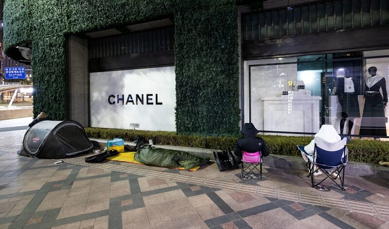 Shoppers wait in line with tents and portable chairs outside a Chanel store in Seoul. Shoppers wait in line with tents and portable chairs outside a Chanel store in Seoul.