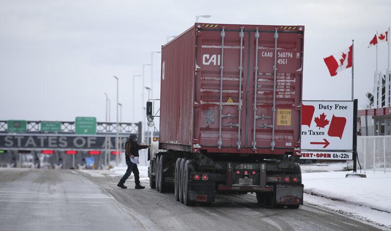 A driver heads back to their truck after stopping at Canadian Customs heading towards the U.S. at the border in St-Bernard-de-Lacolle, Quebec, Canada, on Friday, Jan. 14, 2021. Canada plans to start turning away unvaccinated U.S. truckers at the border this weekend, a move that threatens to upend the flow of everything from food to auto parts to building supplies between two of the world's largest trading partners. Photographer: Christinne Muschi/Bloomberg A driver heads back to their truck after stopping at Canadian Customs heading towards the U.S. at the border in St-Bernard-de-Lacolle, Quebec, Canada, on Friday, Jan. 14, 2021. Canada plans to start turning away unvaccinated U.S. truckers at the border this weekend, a move that threatens to upend the flow of everything from food to auto parts to building supplies between two of the world's largest trading partners. Photographer: Christinne Muschi/Bloomberg