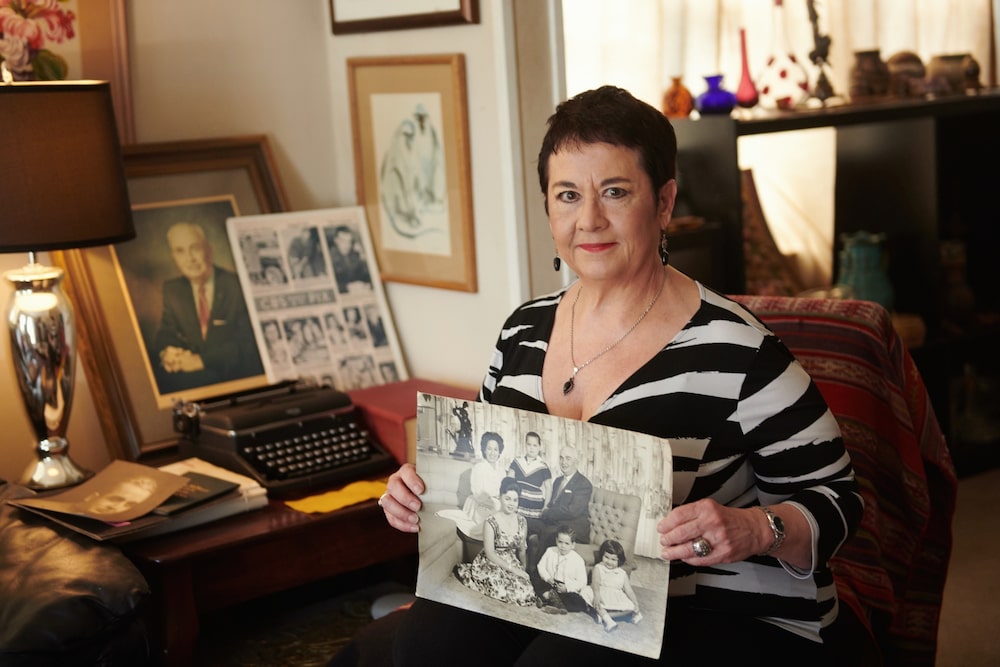 Carolyn Chester sostiene una fotografía de su infancia en la esquina inferior derecha, junto a sus padres, Edmund y Enna "Nena" Chester, y sus hermanos, en su casa de Florida. Fotógrafo: Dan Brouillette/Bloomberg Carolyn Chester sostiene una fotografía de su infancia en la esquina inferior derecha, junto a sus padres, Edmund y Enna "Nena" Chester, y sus hermanos, en su casa de Florida. Fotógrafo: Dan Brouillette/Bloomberg