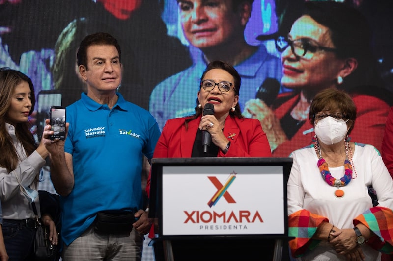Xiomara Castro, candidata presidencial del partido Libertad y Refundación (LIBRE), segunda desde la derecha, habla durante un mitin de la noche electoral en Tegucigalpa, Honduras, el domingo 28 de noviembre de 2021. Los hondureños votan este domingo en unas elecciones presidenciales que pueden desbancar al partido gobernante, salpicado de escándalos, y poner fin a la alianza de la nación con Taiwán. Xiomara Castro, candidata presidencial del partido Libertad y Refundación (LIBRE), segunda desde la derecha, habla durante un mitin de la noche electoral en Tegucigalpa, Honduras, el domingo 28 de noviembre de 2021. Los hondureños votan este domingo en unas elecciones presidenciales que pueden desbancar al partido gobernante, salpicado de escándalos, y poner fin a la alianza de la nación con Taiwán.