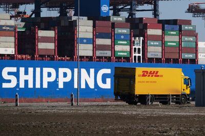 Un camión de DHL Worldwide Express pasa junto a un buque de carga de China Ocean Shipping Group Co. (COSCO) atracado en la terminal Euromax del puerto de Rotterdam en Rotterdam, Países Bajos, el martes 24 de marzo. 24, 2020. Fotógrafa: Yuriko Nakao/Bloomberg