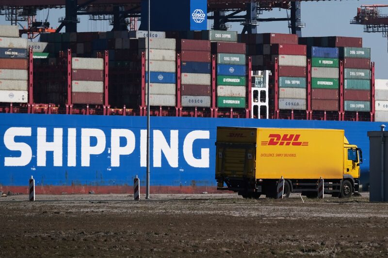 Un camión de DHL Worldwide Express pasa junto a un buque de carga de China Ocean Shipping Group Co. (COSCO) atracado en la terminal Euromax del puerto de Rotterdam en Rotterdam, Países Bajos, el martes 24 de marzo. 24, 2020. Fotógrafa: Yuriko Nakao/Bloomberg Un camión de DHL Worldwide Express pasa junto a un buque de carga de China Ocean Shipping Group Co. (COSCO) atracado en la terminal Euromax del puerto de Rotterdam en Rotterdam, Países Bajos, el martes 24 de marzo. 24, 2020. Fotógrafa: Yuriko Nakao/Bloomberg
