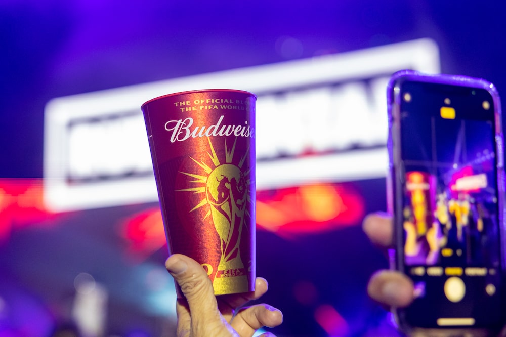 A fan takes a smartphone photograph of a Budweiser beer at the BudX FIFA Fan Festival at Dubai Harbour in Dubai, United Arab Emirates, on Tuesday, Nov. 29, 2022. Doha is expected to welcome more than 1 million fans during the FIFA World Cup 2022, but many of them will be staying in Dubai and other surrounding cities, taking shuttle flights in for the day. Photographer: Christopher Pike/Bloomberg A fan takes a smartphone photograph of a Budweiser beer at the BudX FIFA Fan Festival at Dubai Harbour in Dubai, United Arab Emirates, on Tuesday, Nov. 29, 2022. Doha is expected to welcome more than 1 million fans during the FIFA World Cup 2022, but many of them will be staying in Dubai and other surrounding cities, taking shuttle flights in for the day. Photographer: Christopher Pike/Bloomberg