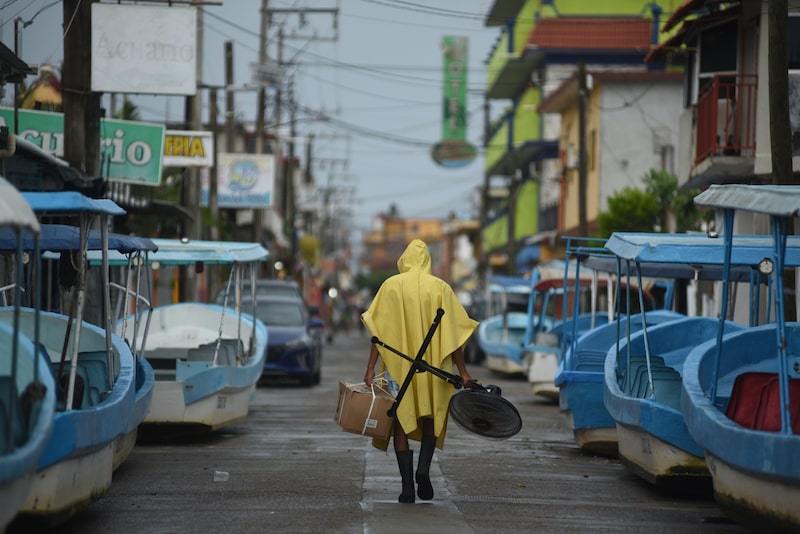 Un residente lleva una caja y un ventilador en una calle vacía después de que el huracán Grace tocó tierra en Tecolitla, estado de Veracruz, México, el viernes 20 de agosto de 2021. Un residente lleva una caja y un ventilador en una calle vacía después de que el huracán Grace tocó tierra en Tecolitla, estado de Veracruz, México, el viernes 20 de agosto de 2021.