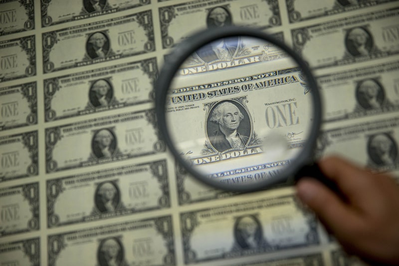 A magnifying glass is held over a 50 subject one dollar note sheet after being printed by an intaglio printing press in Washington, D.C., U.S. Photographer: Andrew Harrer/Bloomberg A magnifying glass is held over a 50 subject one dollar note sheet after being printed by an intaglio printing press in Washington, D.C., U.S. Photographer: Andrew Harrer/Bloomberg