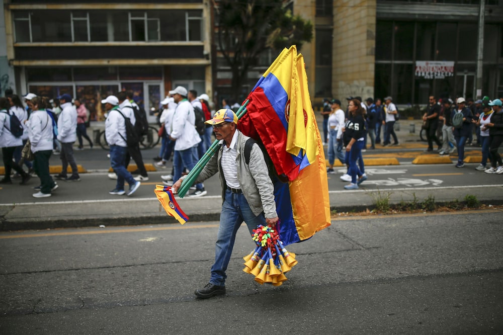 A vendor sells flags during a pro-government march to Bolivar Square in Bogota, Colombia, on Tuesday, Feb. 14, 2023. President Gustavo Petros plans to overhaul the Colombian welfare state are facing their first big test as his supporters take to the streets to pressure lawmakers debating his controversial health care bill. Photographer: Ivan Valencia/Bloomberg A vendor sells flags during a pro-government march to Bolivar Square in Bogota, Colombia, on Tuesday, Feb. 14, 2023. President Gustavo Petros plans to overhaul the Colombian welfare state are facing their first big test as his supporters take to the streets to pressure lawmakers debating his controversial health care bill. Photographer: Ivan Valencia/Bloomberg