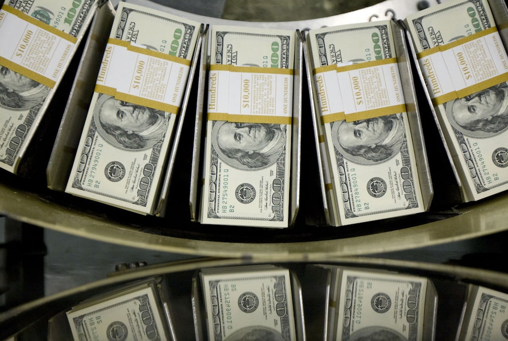 Fajos de billetes de cien dólares pasan por una máquina circuladora en Washington. Fajos de billetes de cien dólares pasan por una máquina circuladora en Washington.