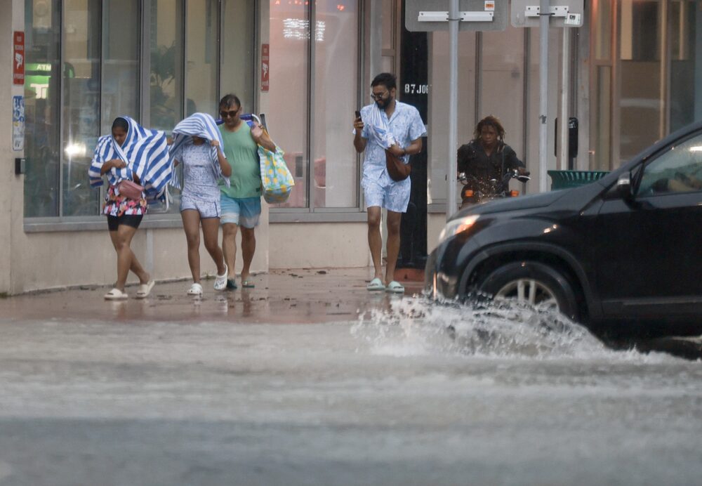 La gente sortea un aguacero en Miami Beach.Fotógrafo: Joe Raedle/Getty Images Norteamérica La gente sortea un aguacero en Miami Beach.Fotógrafo: Joe Raedle/Getty Images Norteamérica