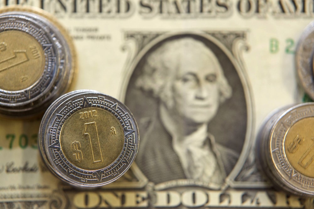 A U.S. one dollar bill and Mexican pesos coins are arranged for a photograph inside a currency exchange center in Mexico City, Mexico, on Tuesday, July 9, 2013. Mexicos peso rose for the first time in three days on July 11 after Federal Reserve Chairman Ben S. Bernanke called for maintaining a U.S. stimulus program that has boosted demand for the Latin American countrys securities. Photographer: Susana Gonzalez/Bloomberg A U.S. one dollar bill and Mexican pesos coins are arranged for a photograph inside a currency exchange center in Mexico City, Mexico, on Tuesday, July 9, 2013. Mexicos peso rose for the first time in three days on July 11 after Federal Reserve Chairman Ben S. Bernanke called for maintaining a U.S. stimulus program that has boosted demand for the Latin American countrys securities. Photographer: Susana Gonzalez/Bloomberg