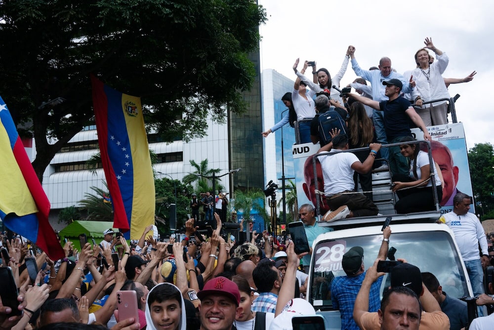 María Corina Machado y Edmundo González saludan a manifestantes desde lo alto de un vehículo durante una protesta por las elecciones venezolanas, el martes en Caracas. María Corina Machado y Edmundo González saludan a manifestantes desde lo alto de un vehículo durante una protesta por las elecciones venezolanas, el martes en Caracas.