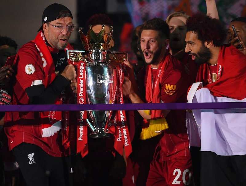 Jurgen Klopp, Adam Lallana y Mohamed Salah, del Liverpool, sostienen el trofeo de la Premier League para celebrar la obtención del título de liga durante la ceremonia de presentación del partido de la Premier League entre el Liverpool FC y el Chelsea FC en Anfield el 22 de julio de 2020 en Liverpool, Inglaterra. Jurgen Klopp, Adam Lallana y Mohamed Salah, del Liverpool, sostienen el trofeo de la Premier League para celebrar la obtención del título de liga durante la ceremonia de presentación del partido de la Premier League entre el Liverpool FC y el Chelsea FC en Anfield el 22 de julio de 2020 en Liverpool, Inglaterra.