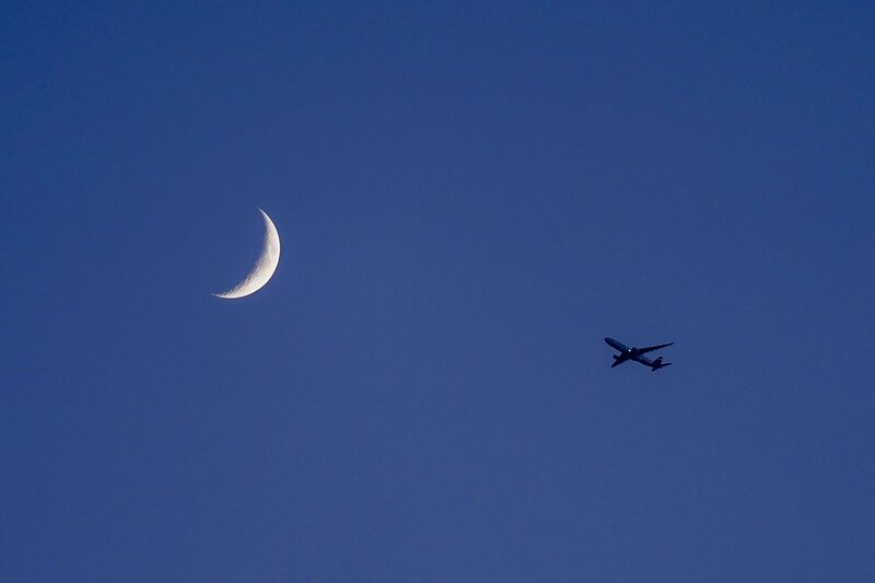 A passenger aircraft flies beneath a crescent moon in Spain. Photographer: Paul Hanna/Bloomberg A passenger aircraft flies beneath a crescent moon in Spain. Photographer: Paul Hanna/Bloomberg