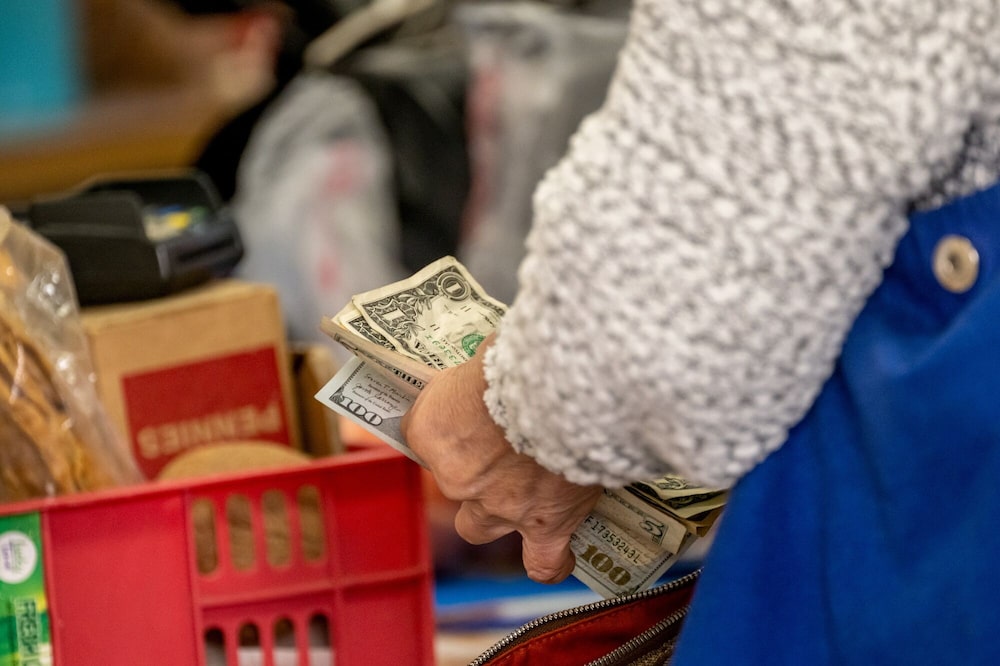 Un comprador sostiene billetes estadounidenses en el barrio de Chinatown de San Francisco, California, EE.UU. Un comprador sostiene billetes estadounidenses en el barrio de Chinatown de San Francisco, California, EE.UU.