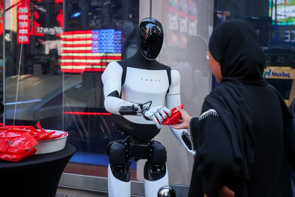 O robô Optimus em interação com uma pessoa durante a fase de testes O robô Optimus em interação com uma pessoa durante a fase de testes