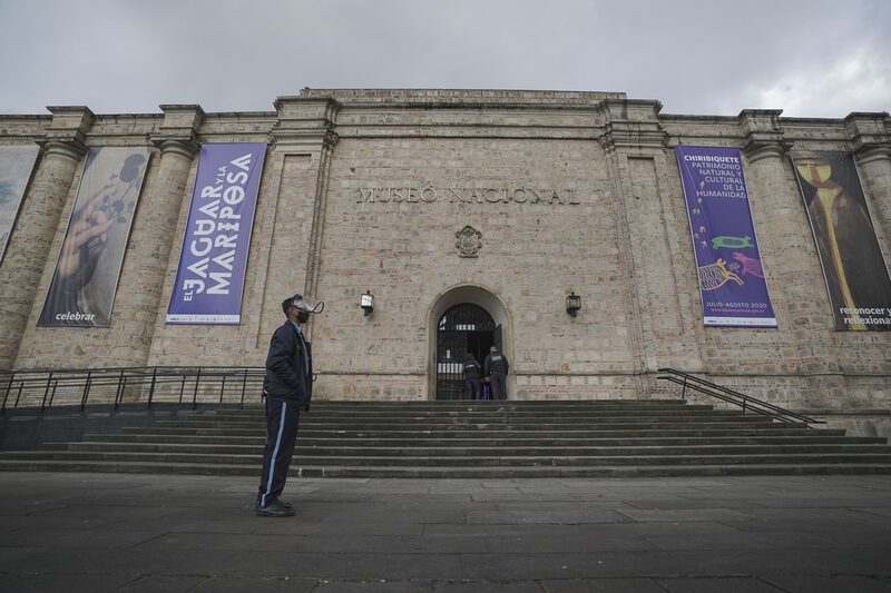 Un guardia de seguridad con una máscara protectora y una careta se encuentra frente al Museo Nacional de Colombia en Bogotá, Colombia, el jueves 6 de agosto de 2020. Un guardia de seguridad con una máscara protectora y una careta se encuentra frente al Museo Nacional de Colombia en Bogotá, Colombia, el jueves 6 de agosto de 2020.