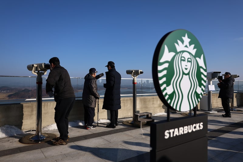 Para las personas que sienten curiosidad por la vida civil norcoreana, Starbucks ofrece a sus clientes del sur un vistazo desde su local al otra lado del río. Para las personas que sienten curiosidad por la vida civil norcoreana, Starbucks ofrece a sus clientes del sur un vistazo desde su local al otra lado del río.