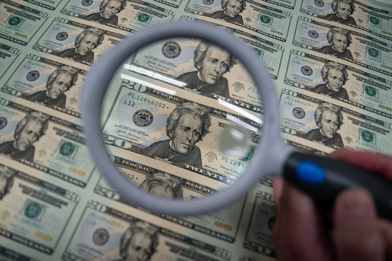 Un trabajador sostiene una lupa sobre una hoja con 50 billetes de US$20 en la Oficina de Grabado e Impresión de Estados Unidos en Washington. Fotógrafo: Al Drago/Bloomberg. Un trabajador sostiene una lupa sobre una hoja con 50 billetes de US$20 en la Oficina de Grabado e Impresión de Estados Unidos en Washington. Fotógrafo: Al Drago/Bloomberg.