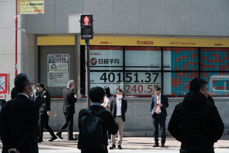 Peatones frente a un tablero electrónico que muestra el Nikkei 225 Stock Average fuera de una firma de valores en Tokio, Japón, el lunes 4 de marzo de 2024. Peatones frente a un tablero electrónico que muestra el Nikkei 225 Stock Average fuera de una firma de valores en Tokio, Japón, el lunes 4 de marzo de 2024.