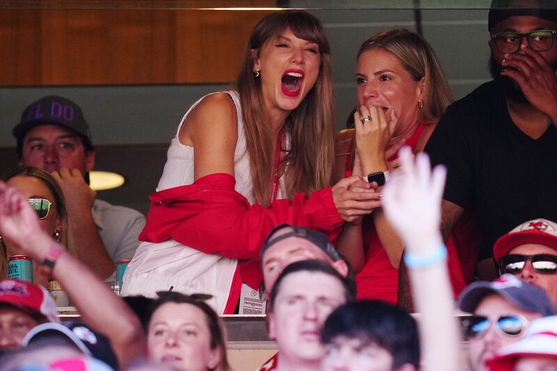Taylor Swift entusiasmada na arquibancada de um estádio Taylor Swift entusiasmada na arquibancada de um estádio