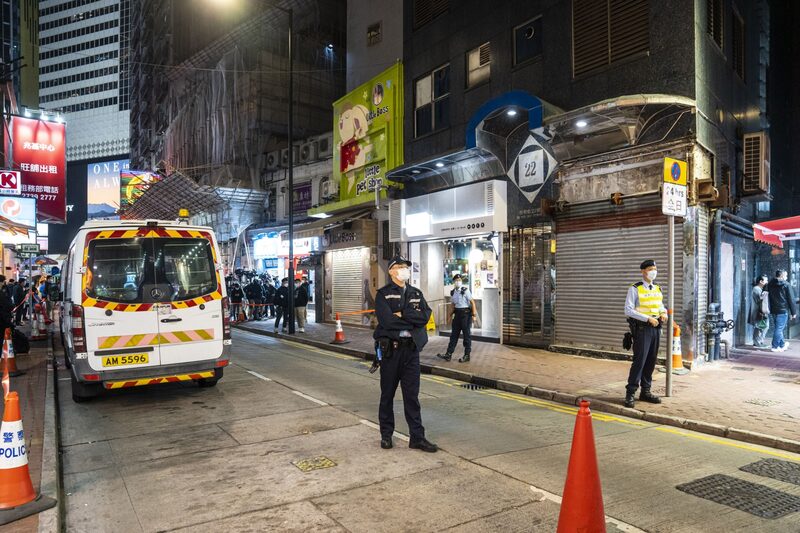 Un oficial de policía de Hong Kong hace guardia fuera de un local de mascotas. Un oficial de policía de Hong Kong hace guardia fuera de un local de mascotas.