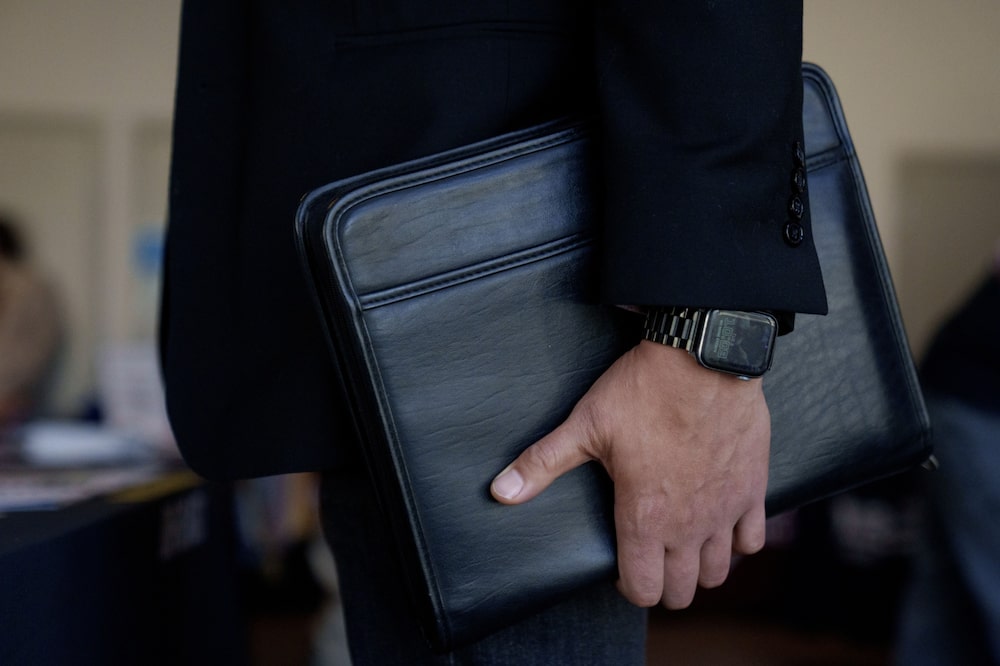 Un hombre sostiende un portafolio Un hombre sostiende un portafolio