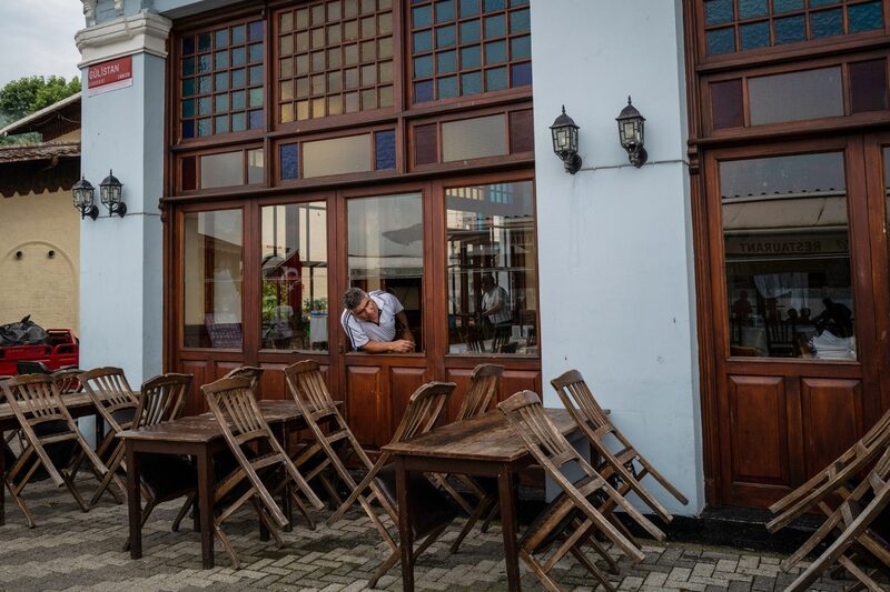Un trabajador de un restaurante junto a mesas vacías en Buyukada, Turquía, el 23 de junio. Un trabajador de un restaurante junto a mesas vacías en Buyukada, Turquía, el 23 de junio.