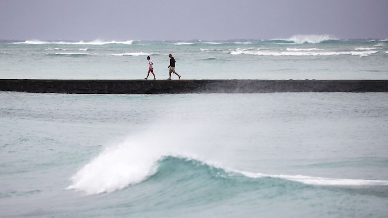 Varias personas caminan por un espigón en la playa de Waikiki, en la isla de Oahu, en Honolulu (Hawái). Varias personas caminan por un espigón en la playa de Waikiki, en la isla de Oahu, en Honolulu (Hawái).