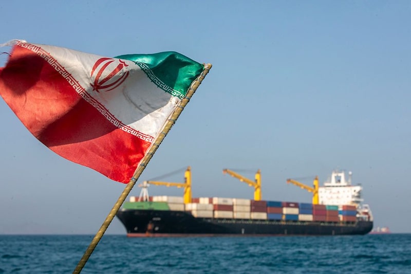 Una bandera iraní ondea al viento mientras varios buques permanecen anclados en el estrecho de Ormuz. Una bandera iraní ondea al viento mientras varios buques permanecen anclados en el estrecho de Ormuz.