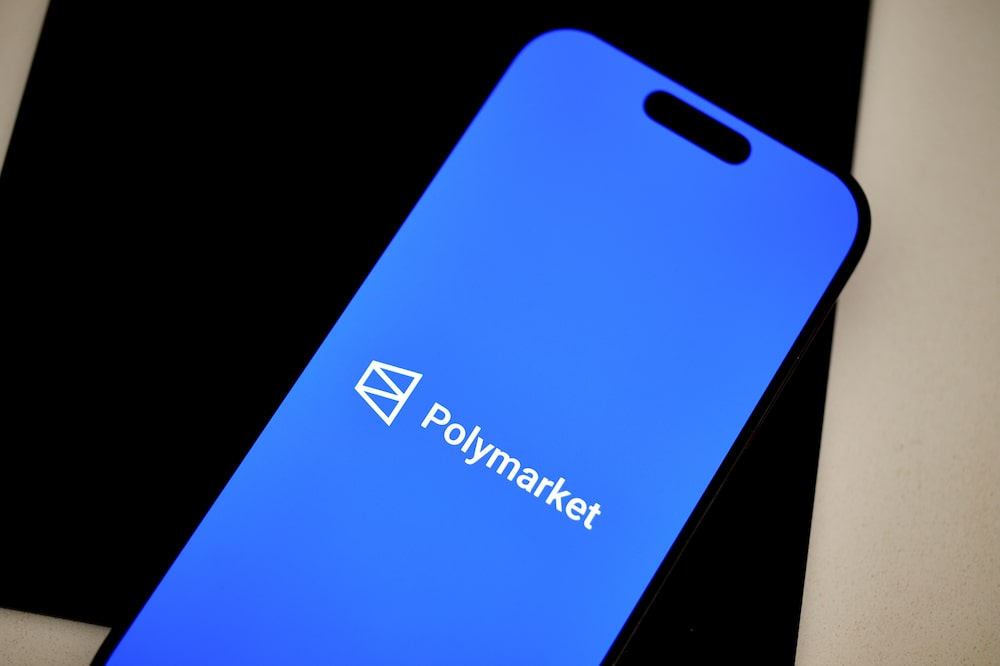 The Polymarket logo on a smartphone arranged in Germantown, New York, US, on Tuesday, July 22, 2025. Polymarket, the crypto-betting platform that was kicked offshore by federal regulators, has struck a deal to return to the US market just weeks after prosecutors shut down a probe of the company. Photographer: Gabby Jones/Bloomberg The Polymarket logo on a smartphone arranged in Germantown, New York, US, on Tuesday, July 22, 2025. Polymarket, the crypto-betting platform that was kicked offshore by federal regulators, has struck a deal to return to the US market just weeks after prosecutors shut down a probe of the company. Photographer: Gabby Jones/Bloomberg