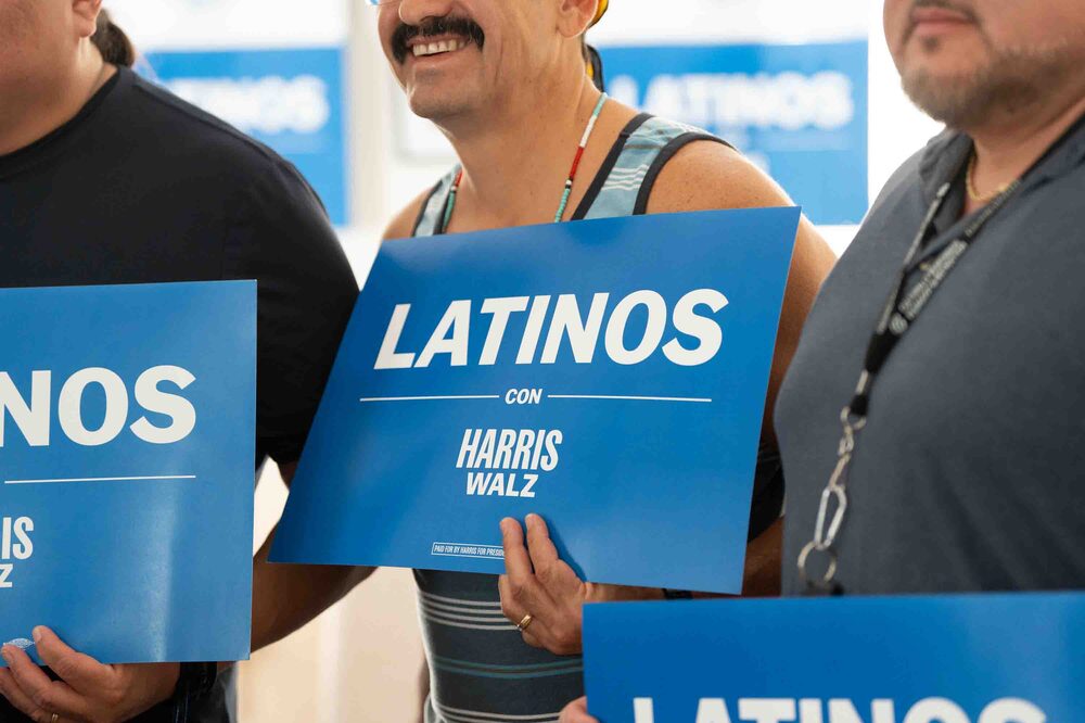 Ray Siqueiros sostiene un cartel de campaña durante un cafecito de Latino Men for Harris en REA Media Group en Tucson, Arizona, EE.UU., el sábado 12 de octubre de 2024. Fotógrafa: Rebecca Noble/Bloomberg Ray Siqueiros sostiene un cartel de campaña durante un cafecito de Latino Men for Harris en REA Media Group en Tucson, Arizona, EE.UU., el sábado 12 de octubre de 2024. Fotógrafa: Rebecca Noble/Bloomberg