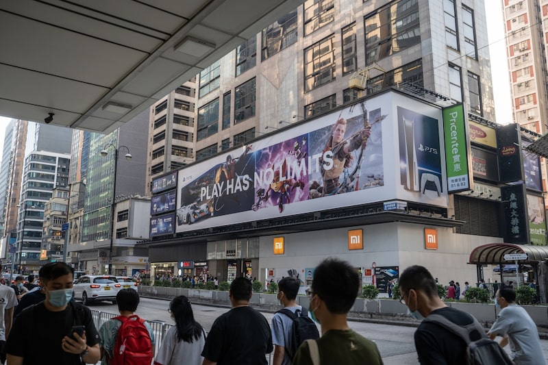 Pedestrians wearing protective mask walk past a billboard advertising the Sony Corp. PlayStation 5 game console in Hong Kong, China, on Thursday, Nov. 26, 2020. The newest video-game console from Sony Corp., alongside rival Microsoft Corp.'s updated Xbox, are arguably the hottest items this Black Friday as shoppers line up in person or swarm retailers' websites hoping to snag one. Photographer: Roy Liu/Bloomberg Pedestrians wearing protective mask walk past a billboard advertising the Sony Corp. PlayStation 5 game console in Hong Kong, China, on Thursday, Nov. 26, 2020. The newest video-game console from Sony Corp., alongside rival Microsoft Corp.'s updated Xbox, are arguably the hottest items this Black Friday as shoppers line up in person or swarm retailers' websites hoping to snag one. Photographer: Roy Liu/Bloomberg