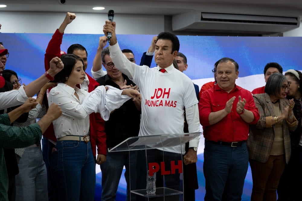 Salvador Nasralla lleva una camiseta que dice "JOH Nunca más" durante una rueda de prensa en Tegucigalpa el 28 de noviembre. Salvador Nasralla lleva una camiseta que dice "JOH Nunca más" durante una rueda de prensa en Tegucigalpa el 28 de noviembre.