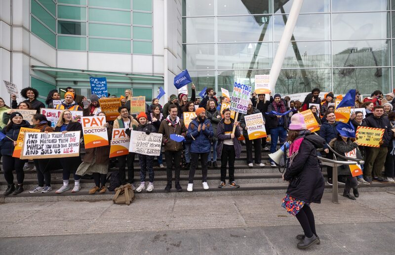 Médicos en formación sostienen pancartas y gritan consignas frente al University College Hospital de Londres (UCLH) en Londres, Reino Unido, el lunes 13 de marzo de 2023. Médicos en formación sostienen pancartas y gritan consignas frente al University College Hospital de Londres (UCLH) en Londres, Reino Unido, el lunes 13 de marzo de 2023.