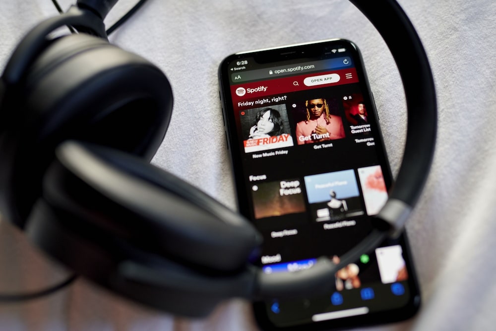 El sitio web de Spotify junto a unos auriculares El sitio web de Spotify junto a unos auriculares