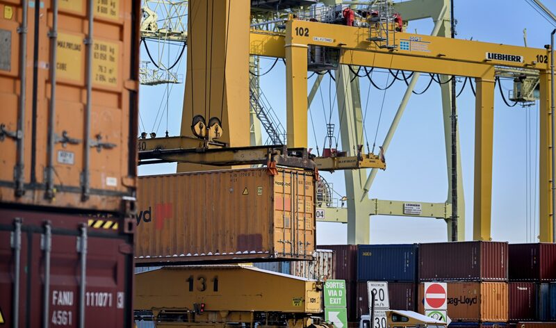 Imagem de um contêiner sendo transportado por uma grua em um navio cargueiro Imagem de um contêiner sendo transportado por uma grua em um navio cargueiro