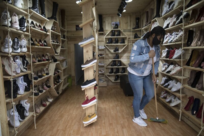 Un trabajador usa una máscara protectora mientras barre el piso de una zapatería en el barrio El Restrepo en Bogotá, Colombia, el jueves 27 de agosto de 2020. Un trabajador usa una máscara protectora mientras barre el piso de una zapatería en el barrio El Restrepo en Bogotá, Colombia, el jueves 27 de agosto de 2020.
