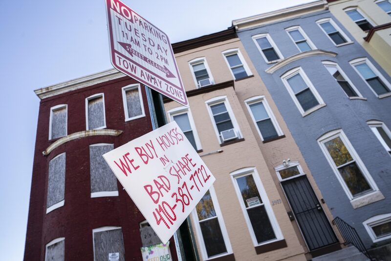 A sign to purchase homes in front of abandoned and inhabited row houses along Walbrook Avenue in West Baltimore, Maryland, US, on Wednesday, Nov. 9, 2022. A sign to purchase homes in front of abandoned and inhabited row houses along Walbrook Avenue in West Baltimore, Maryland, US, on Wednesday, Nov. 9, 2022.